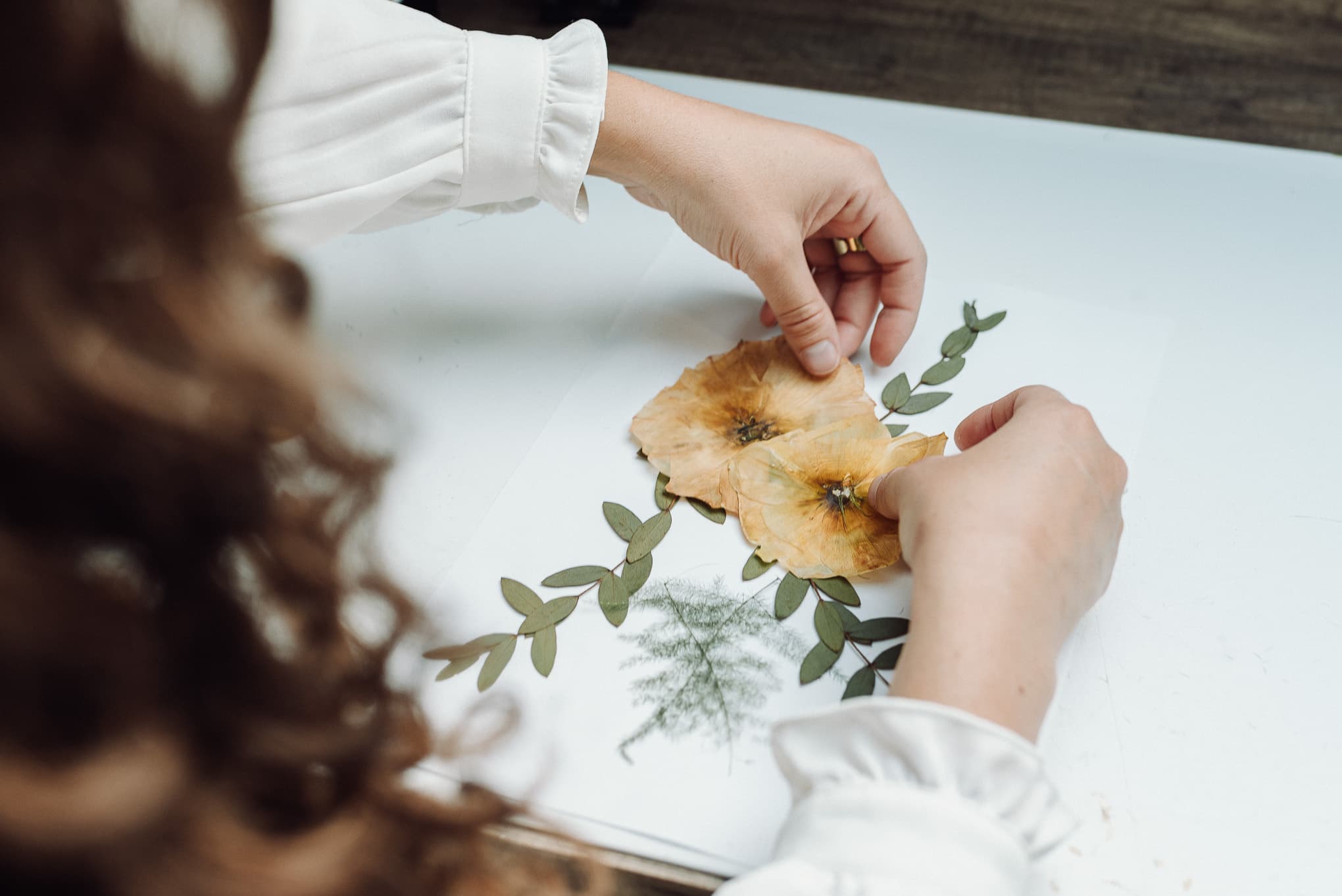 Mains travaillant des fleurs séchées